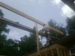 Carpenter setting a ridge beam over a new addition frame — Ice Dam Removal by Roofing Brothers in Rich Square