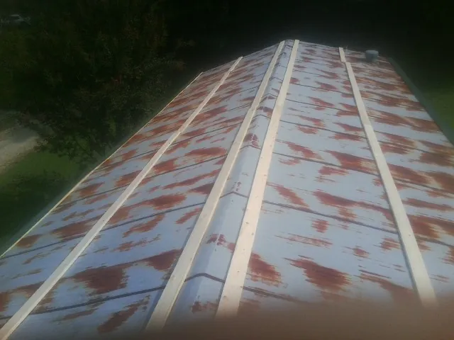 Rusted metal roof panels with new wood purlins before replacement — Storm Damage Roof Repair in Rich Square by Roofing Brothers