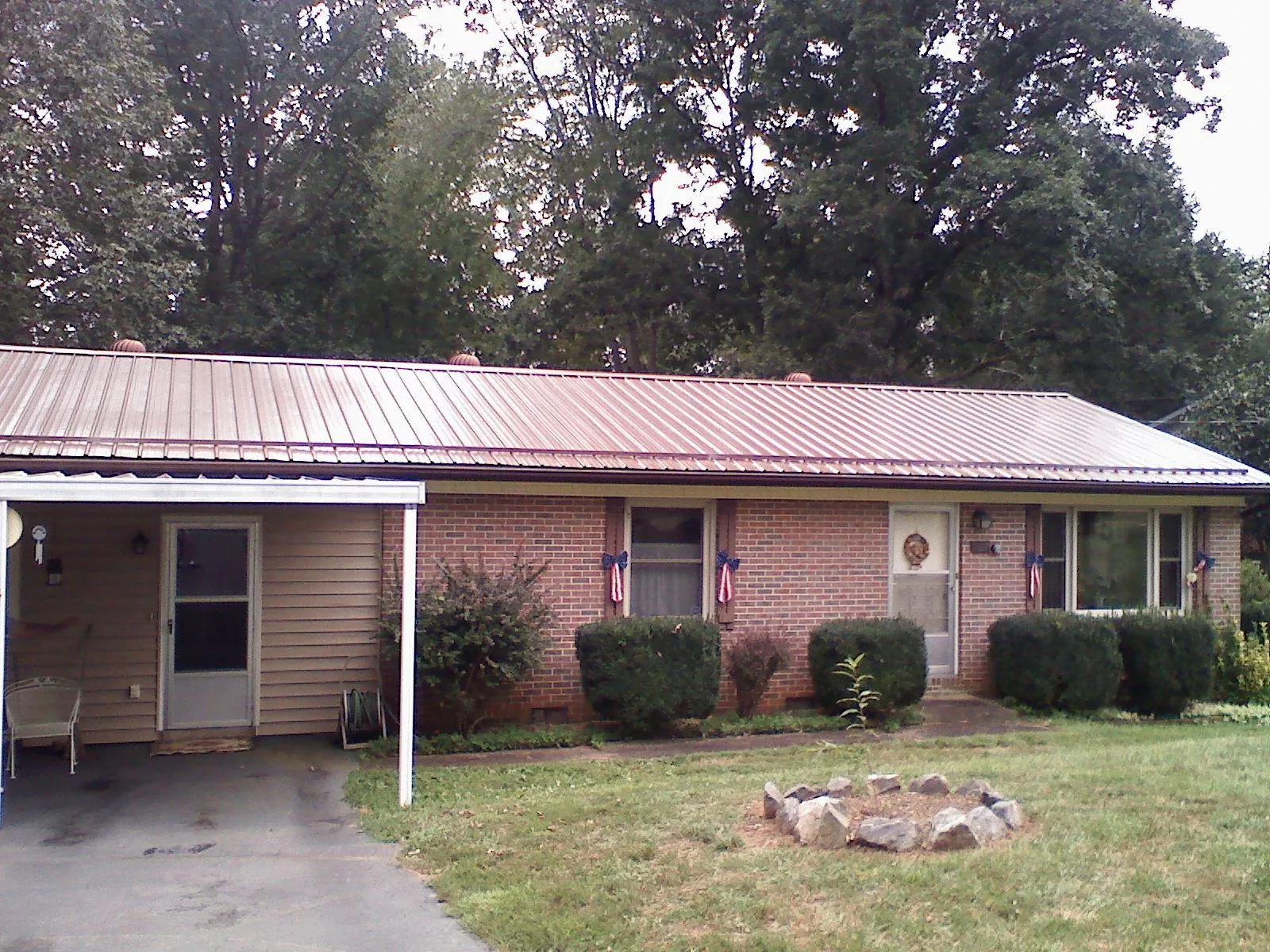 Bronze metal roof and carport on a brick ranch home — Roof Repair work by our crew in Rich Square